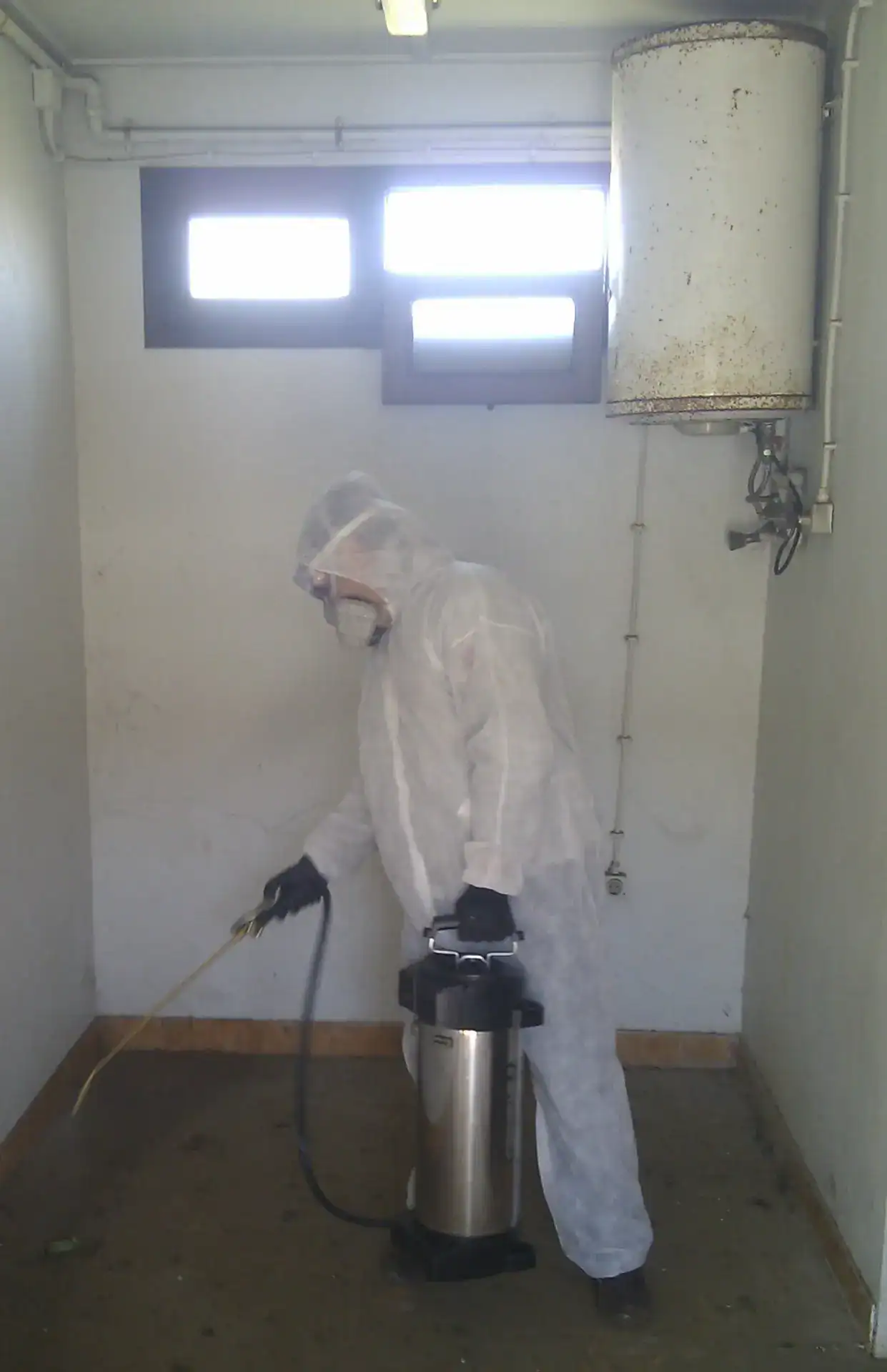 Profissional usando equipamento de limpeza industrial em ambiente fechado.